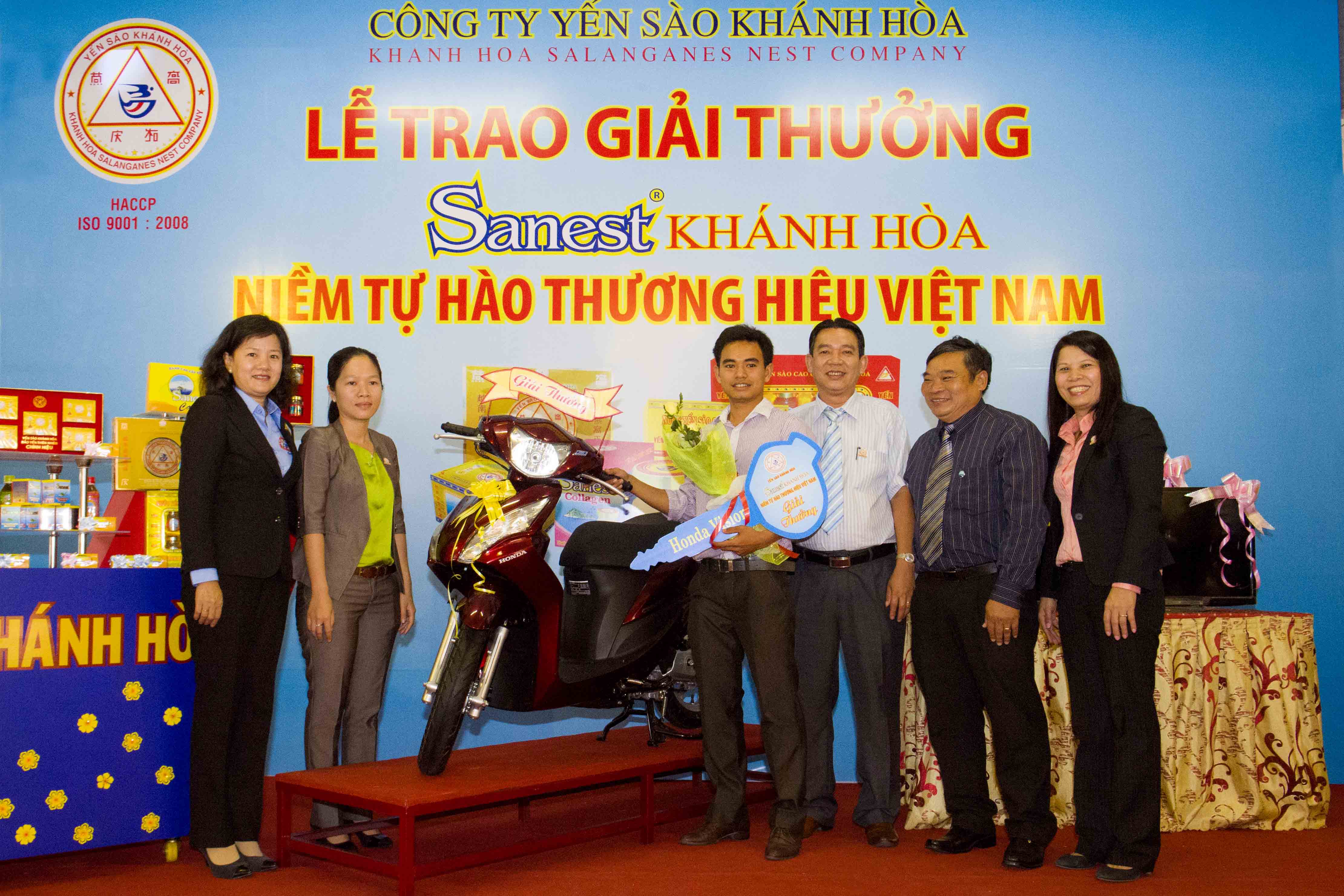 Khách hàng Nguyễn Ngô Bá Toàn (thứ 4 từ phải sang) nhận giải thưởng xe máy Honda Vision.
